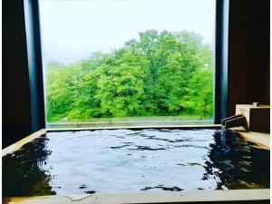 uma vista para uma piscina a partir de uma janela em Kajitsu no mori - Vacation STAY 53781v em Ichinoseki