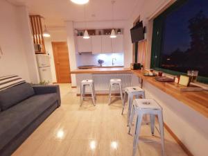 sala de estar con sofá y cocina con taburetes en apartamento Vigo Samil, en Vigo