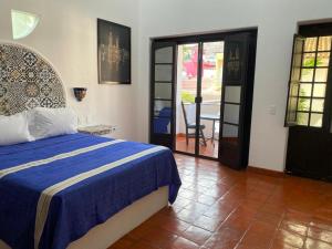 - une chambre avec un lit et une couverture bleue dans l'établissement Casa Yollotzin, à Ajijic