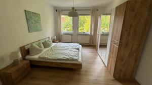 um quarto com uma cama e uma grande janela em Bitterfelder Cityapartment im Dichterviertel em Bitterfeld