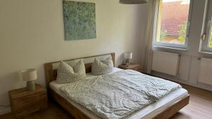 um quarto com uma cama com lençóis brancos e almofadas em Bitterfelder Cityapartment im Dichterviertel em Bitterfeld