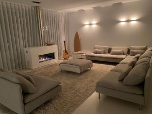 ein Wohnzimmer mit 2 Sofas und einem Kamin in der Unterkunft Villa Surf Vista - Praia da Areia Branca in Lourinhã