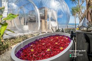 un jardín de flores en una bañera de flores rojas y moradas en Bubble Hotel Nyang Nyang - Adults only, en Uluwatu