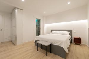 a bedroom with a large white bed and a mirror at Maison Nona in Torre del Greco