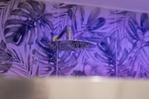 a shower head in a bathroom with purple wallpaper at Maison Nona in Torre del Greco