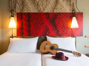 een gitaar op een bed bij ibis Edinburgh Centre Royal Mile – Hunter Square in Edinburgh