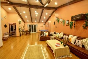 un soggiorno con divano e tavolo di Elsewhere Villa by Hill Staytion a Mahabaleshwar