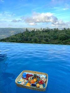 ein Tablett mit Lebensmitteln auf einem Wasserkörper in der Unterkunft Elsewhere Villa by Hill Staytion in Mahabaleshwar