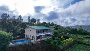 eine Luftansicht eines Hauses mit Pool in der Unterkunft Elsewhere Villa by Hill Staytion in Mahabaleshwar