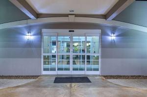 une porte en verre dans un bâtiment avec fenêtre dans l'établissement La Quinta by Wyndham Bowling Green, à Bowling Green