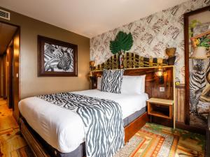 een slaapkamer met een bed met een zebraprint-muur bij Chessington Hotel in Chessington