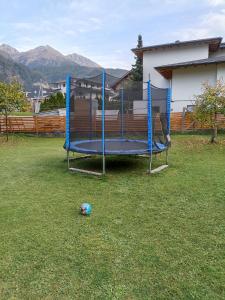 un trampolino blu in un cortile con una palla nell'erba di Apart ban Voltas a Umhausen