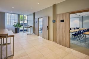 - un hall de bureau avec un coin repas doté de tables et de chaises dans l'établissement Courtyard by Marriott Dortmund, à Dortmund