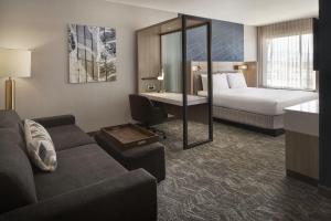 een hotelkamer met een bank, een bed en een bureau bij SpringHill Suites by Marriott Las Vegas Airport in Las Vegas