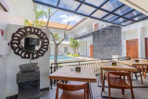 une chambre avec des tables, un miroir et une piscine dans l'établissement The Baliem Hotel, à Jimbaran