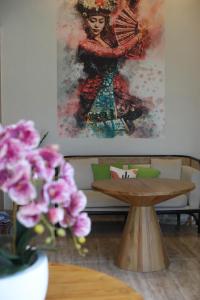 d'une table avec une peinture sur le mur et des fleurs dans l'établissement The Baliem Hotel, à Jimbaran