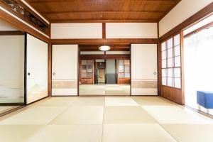 NagashimaにあるNagashima Traditional Houseのガラスドアとタイルフロアの空きロビー