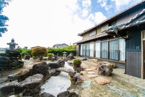 NagashimaにあるNagashima Traditional Houseの建物前の岩庭園