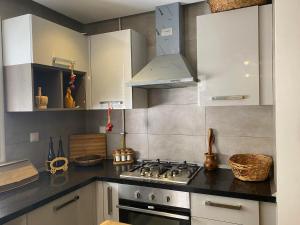 cocina con armarios blancos y fogones en luxe et confort appartement Sahloul 4, en Sousse