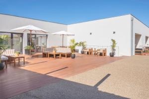 a patio with tables and chairs and umbrellas at BFRESH Hotel - Padel, Pool & Fitness - Adults Only in Porto