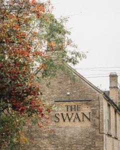 un bâtiment en briques avec le cygne écrit sur lui dans l'établissement The Swan Inn, à Shipton under Wychwood