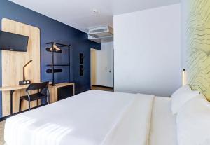 a bedroom with a large white bed and a desk at B&B HOTEL Dijon Centre in Dijon