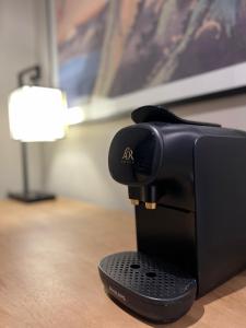 une cafetière noire assise sur une table avec une lampe dans l'établissement Kyoto Rooms Winchester, à Winchester