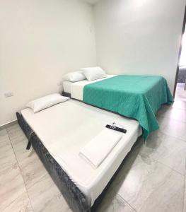 two beds sitting next to each other in a room at Bonito Apartamento Monteria in Montería