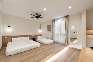 een slaapkamer met 2 bedden en een plafondventilator bij Codrington House - Boutique Apartments in George Town