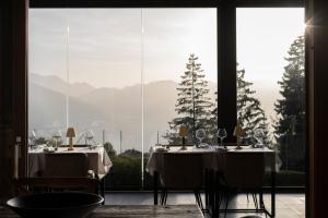 ein Esszimmer mit 2 Tischen und einem großen Fenster in der Unterkunft Les Mazots du Clos in Villars-sur-Ollon