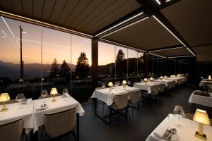 ein Restaurant mit weißen Tischen und Stühlen mit Aussicht in der Unterkunft Les Mazots du Clos in Villars-sur-Ollon