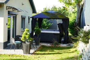 um gazebo com uma mesa e cadeiras num quintal em Secret Garden Vendégház em Pécs