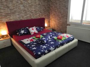 1 dormitorio con 1 cama grande con almohadas patrióticas en ZLATÁ-ÉRA, en Ostrava