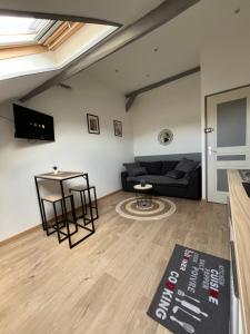 salon z czarną kanapą i stołem w obiekcie Au Bouquet Troyen - Wifi - Calme et tranquillité w Troyes