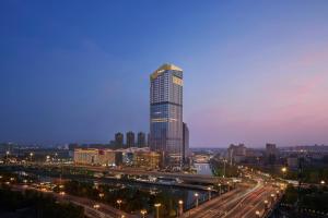 a tall skyscraper in a city at night at Yancheng Marriott Hotel in Yancheng