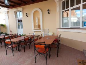 un patio con mesas y sillas en un restaurante en Gyulai Meseház Apartman, en Gyula