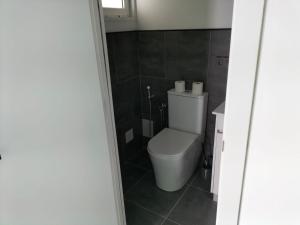 ein Badezimmer mit einem weißen WC und Fliesenboden in der Unterkunft VV Las Buganvillas MASPALOMAS - Cocina y habitaciones con baños privados in Maspalomas