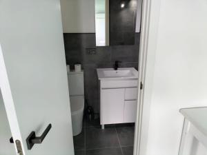 ein Badezimmer mit einem weißen Waschbecken und einem WC in der Unterkunft VV Las Buganvillas MASPALOMAS - Cocina y habitaciones con baños privados in Maspalomas