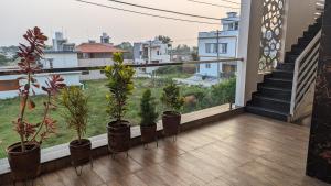 - un balcon avec des plantes en pot et des escaliers dans un bâtiment dans l'établissement SindooRa, à Mysore