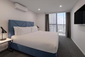 Un pat sau paturi într-o cameră la Meriton Suites Broadbeach