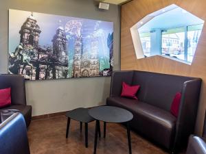 a waiting room with a couch and two tables at B&B Hotel Nürnberg-City in Nürnberg