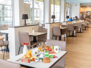 a table with a plate of food on it at B&B Hotel Nürnberg-City in Nürnberg