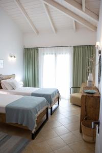 een hotelkamer met 2 bedden en een bank bij Ionian Calm Villas in Vasiliki