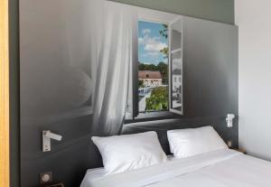 una camera con un letto e una grande finestra di B&B HOTEL Troyes Saint-Parres-aux-Tertres a Saint-Parres-aux-Tertres