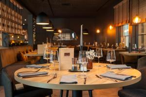 une table dans un restaurant avec des verres et des serviettes dans l'établissement Hotel Novum, à Hinte