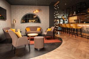 un restaurant avec des chaises et un bar dans l'établissement Hotel Novum, à Hinte