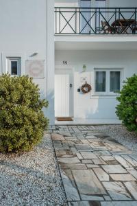 una casa bianca con un sentiero in pietra davanti di Raminhos Guest House a Vila Nova de Milfontes