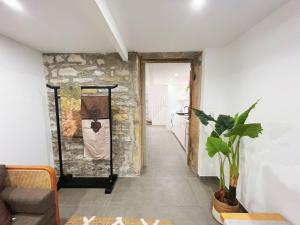 una sala de estar con una pared de piedra y una planta en Bellecour Pavillon, en Lyon