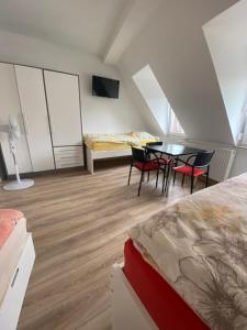 1 dormitorio con 1 cama, mesa y sillas en Annie´s Appartements, en Mannheim