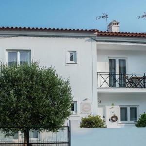 un edificio bianco con un albero di fronte di Raminhos Guest House a Vila Nova de Milfontes